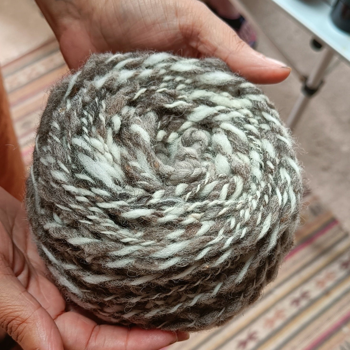 Hand holding a ball of hand spun yarn 